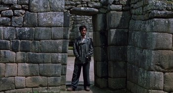 Movie still from “The Motorcycle Diaries” (2004), directed by Walter Salles – A man standing in front of an archway in a stone structure; Wide shot, Low angle
