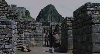 Movie still from “The Motorcycle Diaries” (2004), directed by Walter Salles – A man taking a picture of another man standing in front of a stone wall; Wide shot, Low angle