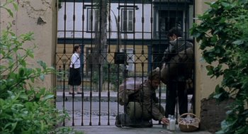 Movie still from “The Motorcycle Diaries” (2004), directed by Walter Salles – A man kneeling on the ground next to a fence; Wide shot, High angle
