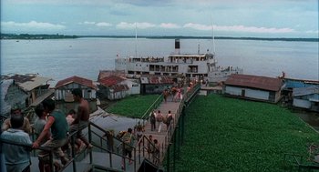 Movie still from “The Motorcycle Diaries” (2004), directed by Walter Salles – A group of people walking down a dock next to a boat; Extreme Wide shot, High angle