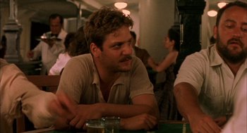Movie still from “The Motorcycle Diaries” (2004), directed by Walter Salles – A man sitting at a table in front of a group of people; Close Up shot, Over the shoulder angle