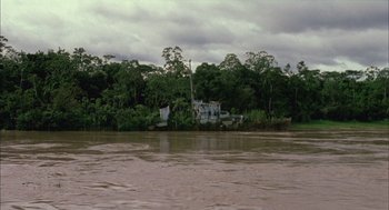 Movie still from “The Motorcycle Diaries” (2004), directed by Walter Salles – A house is sitting on the bank of a river; Extreme Wide shot, High angle