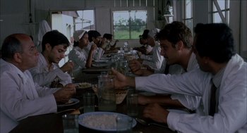 Movie still from “The Motorcycle Diaries” (2004), directed by Walter Salles – A group of people sitting at a table eating food; Medium shot, Low angle