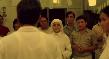 Movie still from “The Motorcycle Diaries” (2004), directed by Walter Salles – A group of men and women standing next to each other in a room; Medium shot, Over the shoulder angle