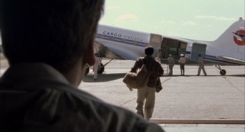 Movie still from “The Motorcycle Diaries” (2004), directed by Walter Salles – A man walking towards an airplane on a runway; Wide shot, Over the shoulder angle