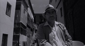 Movie still from “The Motorcycle Diaries” (2004), directed by Walter Salles – A black and white photo of a man wearing a hat; Medium shot, Low angle