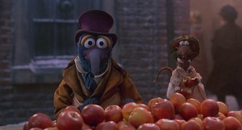 Movie still from “The Muppet Christmas Carol” (1992), directed by Brian Henson – A couple of puppets sitting in a pile of apples; Medium shot, High angle