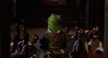 Movie still from “The Muppet Christmas Carol” (1992), directed by Brian Henson – A group of people dressed up as kermit the frog; Medium shot, Low angle
