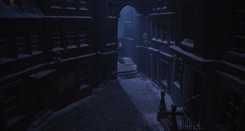 Movie still from “The Muppet Christmas Carol” (1992), directed by Brian Henson – A dark alley with a door open in the middle of the night; Extreme Wide shot, High angle