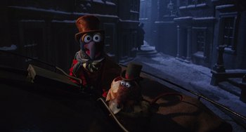 Movie still from “The Muppet Christmas Carol” (1992), directed by Brian Henson – A couple of puppets sitting next to each other on a table; Medium shot, High angle