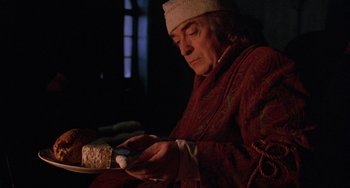 Movie still from “The Muppet Christmas Carol” (1992), directed by Brian Henson – An older man is looking at his cell phone; Close Up shot, Over the shoulder angle