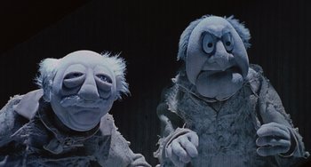 Movie still from “The Muppet Christmas Carol” (1992), directed by Brian Henson – A couple of people that are standing next to each other; Medium shot, Low angle