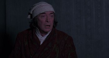 Movie still from “The Muppet Christmas Carol” (1992), directed by Brian Henson – A man wearing a robe and a hat; Close Up shot, Over the shoulder angle