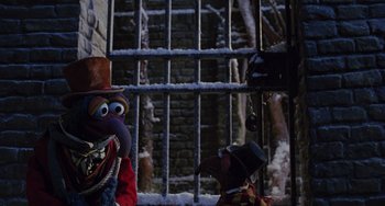Movie still from “The Muppet Christmas Carol” (1992), directed by Brian Henson – Two puppets in front of an iron gate; Medium shot, High angle