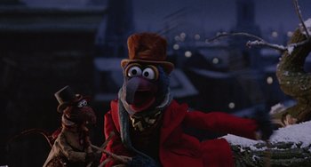 Movie still from “The Muppet Christmas Carol” (1992), directed by Brian Henson – A muppet wearing a red coat and a brown hat; Medium shot, Low angle