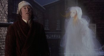 Movie still from “The Muppet Christmas Carol” (1992), directed by Brian Henson – A man standing in front of a projected image of a woman; Medium shot, Low angle