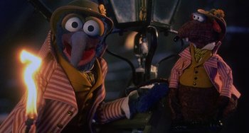 Movie still from “The Muppet Christmas Carol” (1992), directed by Brian Henson – A person dressed up as a bird with a hat and gloves on; Close Up shot, High angle