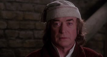 Movie still from “The Muppet Christmas Carol” (1992), directed by Brian Henson – A person wearing a hat; Close Up shot, Over the shoulder angle