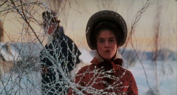 Movie still from “The Muppet Christmas Carol” (1992), directed by Brian Henson – A woman wearing a hat standing next to a tree; Close Up shot, Low angle