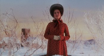 Movie still from “The Muppet Christmas Carol” (1992), directed by Brian Henson – A woman in a red coat standing in the snow; Medium shot, Low angle