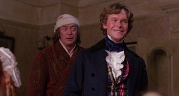 Movie still from “The Muppet Christmas Carol” (1992), directed by Brian Henson – A man in a blue jacket standing next to another man in a red robe; Medium shot, Over the shoulder angle