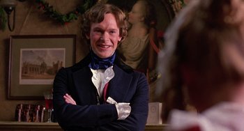 Movie still from “The Muppet Christmas Carol” (1992), directed by Brian Henson – A man in a suit and tie standing with his arms crossed; Close Up shot, Over the shoulder angle