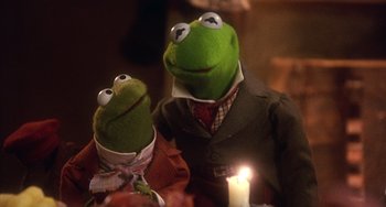 Movie still from “The Muppet Christmas Carol” (1992), directed by Brian Henson – A couple of stuffed animals sitting next to each other on top of a table; Medium shot, Over the shoulder angle