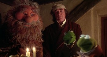 Movie still from “The Muppet Christmas Carol” (1992), directed by Brian Henson – A man standing in front of a group of puppets; Medium shot, Over the shoulder angle