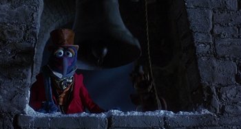 Movie still from “The Muppet Christmas Carol” (1992), directed by Brian Henson – The muppet character gonzo is sitting on a ledge; Medium shot, Low angle
