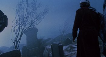 Movie still from “The Muppet Christmas Carol” (1992), directed by Brian Henson – A person standing in a cemetery at night; Wide shot, Low angle