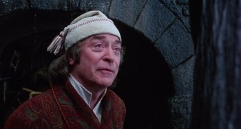 Movie still from “The Muppet Christmas Carol” (1992), directed by Brian Henson – An older man wearing a white hat and a red jacket; Close Up shot, Low angle