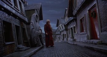 Movie still from “The Muppet Christmas Carol” (1992), directed by Brian Henson – A man in a red robe standing on a cobblestone street; Wide shot, Low angle