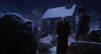 Movie still from “The Muppet Christmas Carol” (1992), directed by Brian Henson – A man in a robe standing in front of a house; Wide shot, Low angle