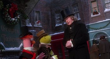 Movie still from “The Muppet Christmas Carol” (1992), directed by Brian Henson – A man in a black top hat and a woman in a black coat and a man in a black top hat and a woman in a black coat; Medium shot, Over the shoulder angle