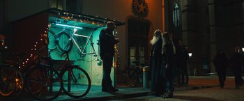 Movie still from “Riders of Justice” (2020), directed by Anders Thomas Jensen – A man standing next to two women in front of a building; Wide shot, Low angle