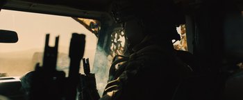 Movie still from “Riders of Justice” (2020), directed by Anders Thomas Jensen – A person is sitting in a helicopter with smoke coming out of the window; Medium shot, Low angle
