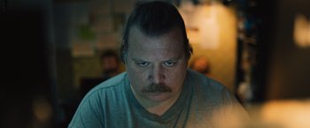 Movie still from “Riders of Justice” (2020), directed by Anders Thomas Jensen – A person with a beard and mustache; Close Up shot, Low angle