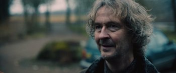 Movie still from “Riders of Justice” (2020), directed by Anders Thomas Jensen – A person wearing a jacket; Close Up shot, Over the shoulder angle