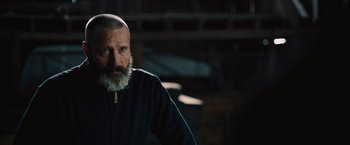 Movie still from “Riders of Justice” (2020), directed by Anders Thomas Jensen – A man with a beard and a white beard is looking at the camera; Close Up shot, Over the shoulder angle