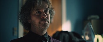 Movie still from “Riders of Justice” (2020), directed by Anders Thomas Jensen – A person wearing a shirt and tie; Close Up shot, Over the shoulder angle