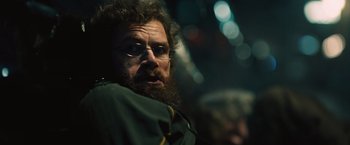 Movie still from “Riders of Justice” (2020), directed by Anders Thomas Jensen – A man with a beard wearing glasses and a green jacket; Close Up shot, Over the shoulder angle