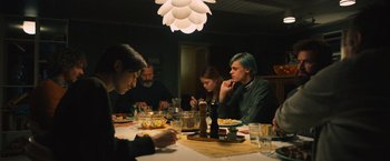 Movie still from “Riders of Justice” (2020), directed by Anders Thomas Jensen – A group of people sitting at a dinner table; Medium shot, Low angle