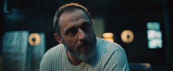 Movie still from “Riders of Justice” (2020), directed by Anders Thomas Jensen – A man with a gray beard is looking at the camera; Close Up shot, Low angle