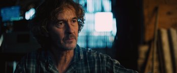 Movie still from “Riders of Justice” (2020), directed by Anders Thomas Jensen – A person wearing a plaid shirt; Close Up shot, Over the shoulder angle