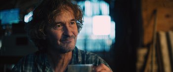 Movie still from “Riders of Justice” (2020), directed by Anders Thomas Jensen – A person holding a cup of coffee; Close Up shot, Over the shoulder angle