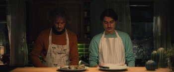 Movie still from “Riders of Justice” (2020), directed by Anders Thomas Jensen – Two men in aprons in a kitchen preparing food; Medium shot, Low angle