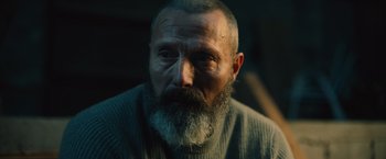 Movie still from “Riders of Justice” (2020), directed by Anders Thomas Jensen – A person with a beard looking at the camera; Close Up shot, High angle