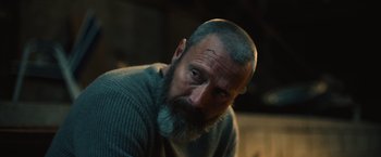 Movie still from “Riders of Justice” (2020), directed by Anders Thomas Jensen – A man with a gray beard is looking at the camera; Close Up shot, Over the shoulder angle