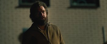 Movie still from “Riders of Justice” (2020), directed by Anders Thomas Jensen – A man with a beard wearing glasses and a sweater; Close Up shot, Over the shoulder angle