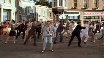 Movie still from “The Muppets” (2011), directed by James Bobin – A group of men in suits and ties dancing in the middle of the street; Wide shot, High angle